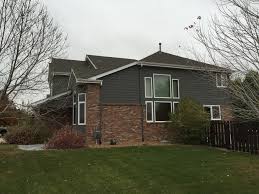 Modest white brick family house with garage and concrete driveway in front. Denver Dark Gray Siding Exterior Craftsman With Garage Door Landscape Architects And Designers Red Brick