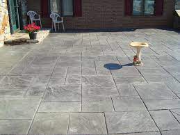 Stamped concrete patios are become more popular than ever, thanks to the unique ability of this surface to create a textured effect that looks a lot more expensive than it is. Stamped Concrete Patio Steel Grey With Dark Grey Release Stamped Concrete Patio Stamped Concrete Concrete Stain Patio