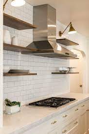 A kitchen wall or mosaic tile will create a feature, as well as acting as a splashback tiled surface for protection against grease from cooking. The Key To Floating Shelves Is A Simple Full Wall Ceramic Tile Backsplash To Give A Stage For Floating Shelves Kitchen White Kitchen Design Kitchen Wall Tiles