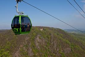 Schroffe felsen, grüne hänge, reißende wildwasser und in der ferne der brocken und die teufelsmauer. Seilbahn Thale Erlebniswelt Akzent Berghotel Rosstrappe