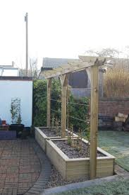 Timber Raised Beds With A Single Pergola Above Growth From The Planted Wisteria And 2 Different Varieties Of Clematis Will Create A Green Privacy Sc Backyard Structures Pergola Screens Backyard Landscaping