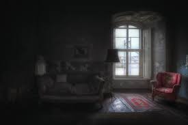 Sofa i fotel przy oknie w ciemnym pokoju