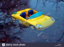 a toy sports car sinking in a puddle of