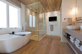 Rustic wood floors provide a dose of warmth in the otherwise white bathroom. 20 Gorgeous Bathrooms With Wooden Floors