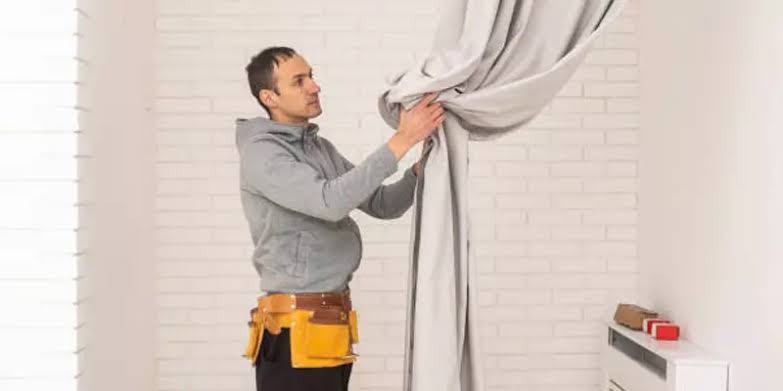 Belvedere fitter installing roller blind bracket on window frame
