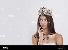 Thinking about miss contest Beauty crowned queen girl woman actress miss  hand on chin face daydreaming planning looking to side isolated white wall.  F Stock Photo - Alamy