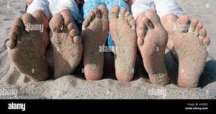Teenagers relax on Southern California beach with sandy feet Stock Photo -  Alamy
