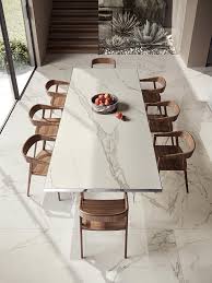 The table legs and top surround are carved with geometrical motifs. Calacatta Extra Atlas Plan Slabs