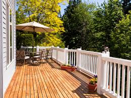 You have a multilevel deck in front of which you see a patio with a fire pit. The True Cost Of Building And Owning A Deck