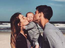 What's the best setting for a family photo? Beach Love Cute Baby Family Happy Kiss Stock Photo 530a8bcf 70b8 43fa B17a 4098e163894e