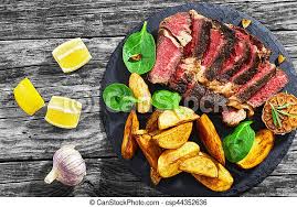 Rest your steaks for 5 minutes before serving, covering lightly with foil. Juicy Rib Eye Beef Steak Medium Rare With Spices Cut In Slices On Slate Plate With Fried Garlic And Spinach Salad And Fried Canstock