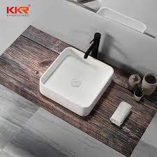 The sleek chrome stand features elegant glass side panels that taper from top to bottom, adding a unique touch to the design. China Modern Lavatory Resin Stone Bathroom Sink And Countertop Sink China Bathroom Sink Artificial Stone Sink