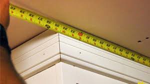 As you can see above, i applied a small bead of wood glue to the trim piece and then taped it to the cabinet with painters tape. How To Install Crown Molding On Kitchen Cabinets