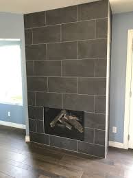 Sleek And Modern Fireplace With Floor To Ceiling Tiles Tiled Fireplace Wall Modern Fireplace Fireplace