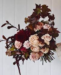 A flowing ribbon was tied to the stems by. Autumn Bouquet With Burgundy Dusty Peach And Autumn Foliage Earth Tone Bouquet Fall Bouquets Burgundy Bouquet
