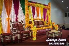 Place votive candles in tall glass vessels, and attach a flower (dahlias are shown here) outside each, trimming the stem to fit and tying with raffia that matches the flower. Baby Shower Decorations Themes And Ideas At Home Sukanya