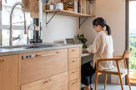 キッチンの天板から連続するかたちで 脇に妻のデスクを設けた キッチンの面材はシナ材にオイル塗装したもの 真鍮の取っ手が風合いを添える 団地 部屋 インテリア 団地インテリア