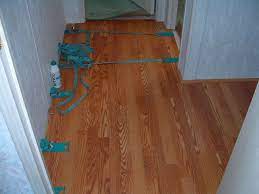 Using The Old Pergo Straps To Hold The Laminate Planks Tight Together Until The Glue Dries Installing Laminate Flooring Laminate Flooring Floor Installation
