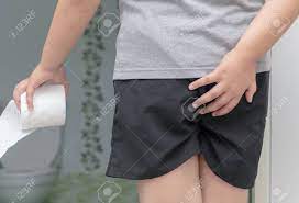 下痢に苦しんでいる子供はトイレットペーパーのロールを保持します。少年は衝動を抑えようとしている自分のお尻を持っています。 Fotos,  retratos, imágenes y fotografía de archivo libres de derecho. Image  100000902