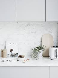 Des Meubles Blanc Un Plan De Travail En Marbre Des Accessoires Blancs Et Bois Clair Pour Une Cuisine Cuisines Lumineuses Cuisine Grise Clair Cuisines Design