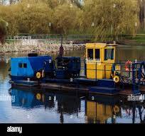 La barca di pulizia del fiume raccoglie i rifiuti sull'acqua ...