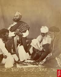 Rajput men playing the game of Puchesee - 1860s A print by Eugene Clutterbuck Impey in the early 1860s showing a group of men from Rajasthan in northern India playing pachisi. This