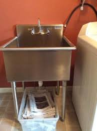 Virtually indestructible laundry tub design with molded in drain. Griffin Products Terrell Series Stainless Steel 27x27 5 In Freestanding 2 Hole Single Compartment Scullery Sink With Lead Free Faucet Te 144 The Home Depot In 2021 Laundry Room Sink Sink Utility Room Sinks