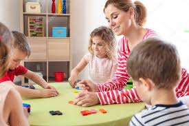 Nursery Teacher With Cute Little Children In Kindergarten Stock Photo Affiliate Cute Teacher Nurse Nursery Teacher Kindergarten Photos School Photos