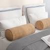 Two standard pillows in beige, two large decorative pillows, and two small textured decorative pillows in a blush hue are stacked upright on top. 1