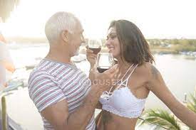 Old man surprised by cute teen girl. Old Man And Young Woman Enjoying Red Wine On A Balcony Around Sunset Happiness Body Art Stock Photo 165721216