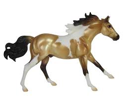 The horse has a tan or gold colored coat with black points (mane, tail, and lower legs). Breyer Horses Classics Size Buckskin Paint 940
