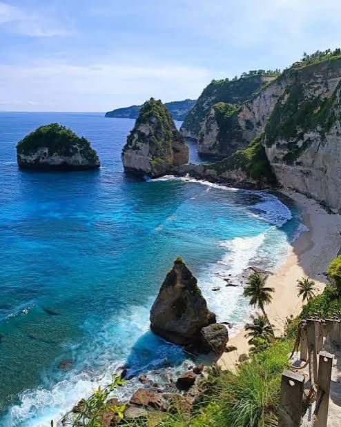 Turquoise ocean waves on a white sand beach in Bali