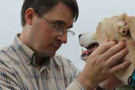 A man petting a dog with his mouth open photo