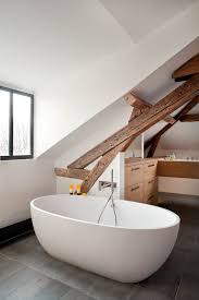 Sloping ceilings, eaves, gable walls and off square corners provide design opportunities rather than limitations when you install dansani bathroom furniture. Imaginative Paris Attic Bathrooms Contemporary Bathroom Sloped Ceiling Wood Beams White Wall Slanted Baignoire Ovale Blanche Carrelage