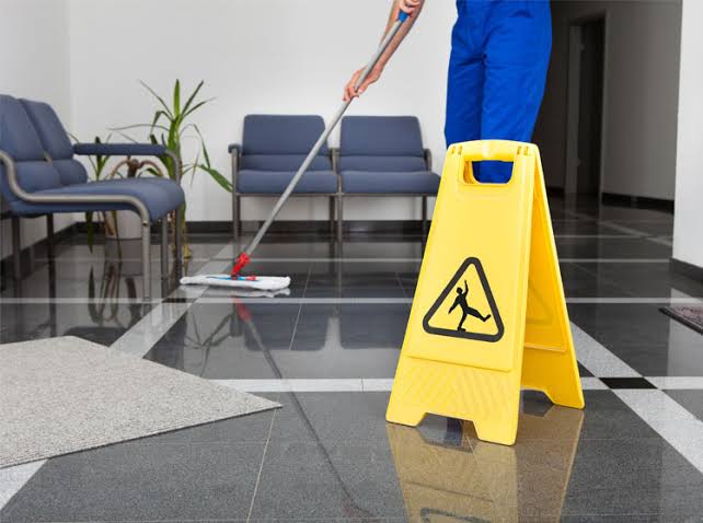 Experienced maid thoroughly cleaning a bright kitchen and living room, mopping hardwood floors, disinfecting high-touch surfaces, polishing fixtures, and removing dust from hard-to-reach areas. The image highlights trusted deep cleaning services near me, deep cleaning house, deep house cleaning services near me, deep clean maid service, and deep cleaning near me, delivering exceptional results with meticulous attention to detail.