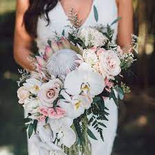 White ivory & blush pastel pink stylish wedding invite, invitation, save the date card design template. A Unqiue Tropical Wedding Bouquet With King Proteas Blush And Mauve Roses Greenery And Tropical Wedding Bouquets Orchid Bouquet Wedding White Orchid Bouquet