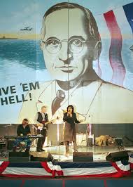 With a banner of Harry S. Truman in the background, recording artist Ruth  Pointer-sayles performs for the crew in the hangar bay of USS HARRY S.  TRUMAN (CVN 75). The Sailors stationed