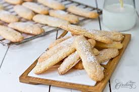 The batter is piped with a piping bag and dusted twice with icing sugar before baking. Homemade Ladyfingers