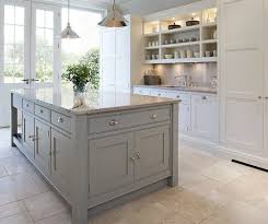 Here, a soft blue paint color makes this island stand out amid white cabinetry, subway tile, and marble countertops. Blue Island Contemporary Shaker Kitchen Kitchen Design Grey Kitchen Island