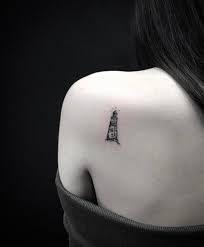 Another tattoo depicting a storm at sea. Small Black And Grey Lighthouse Tattoo On The Left Shoulder Blade Lighthouse Tattoo Small Tattoos For Guys Small Shoulder Tattoos