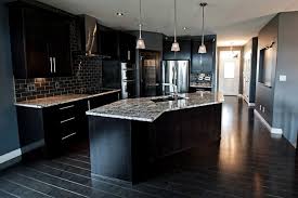Dark Cabinetry Compliments This Corner Kitchen Featuring White Counter Tops And Z Shaped Island The Wendal Harmony House Kitchen White Counters
