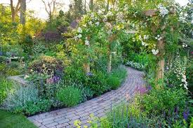 The Narrow Weathered Brick Pathway Creates A Contrast To The Dense Planting And Twists Out Of Country Garden Design Cottage Garden Design Rose Garden Design