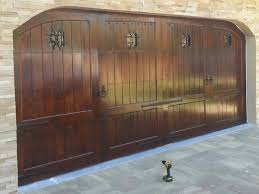 This alder wood garage door has been hand distressed and adorned with rustic iron hardware to give it a flair of the spanish colonial architecture typically found in santa barbara, ca. Spanish Style Custom Wood Garage Door Adriano By Pena