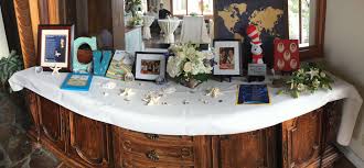 Memory Table At A Celebration Of Life Memorial Incorporating Beach Theme And Favorite Book From Dr Seuss Celebration Of Life Memorial Service Memory Table