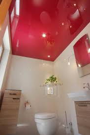 Modernes badezimmer mit grauen schränken, wandtoilette, grauen fliesen, brauner wandfarbe modernes badezimmer en suite mit flächenbündigen schrankfronten, hellbraunen holzschränken. Spanndecken Deckengestaltung Einer Neuen Generation