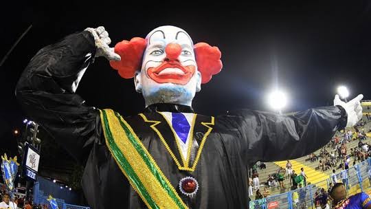 Paulo - ESCULTURA DA VIGÁRIO GERAL DÁ O TOM DO CARNAVAL! Com uma escultura  de palhaço Bozo vestido de terno, faixa presidencial e fazendo arminha, a  Escola abriu os desfiles da série