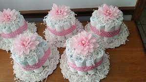 These are so easy to customize and make your own. Small Diaper Cakes For Baby Girl Shower Diy Baby Girl Girl Baby Shower Centerpieces Baby Shower Diaper Cake Baby Shower Centerpieces