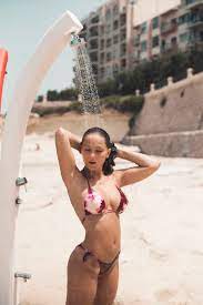 Teenage girl taking a shower on the beach stock photo