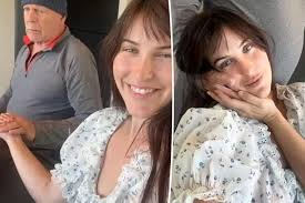 Bruce Willis gently holds onto his daughter's hand