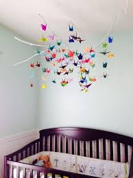 Bunte Origami Kraniche Schweben Uber Dem Babybett Baby Diy Selber Basteln Baby Mobile